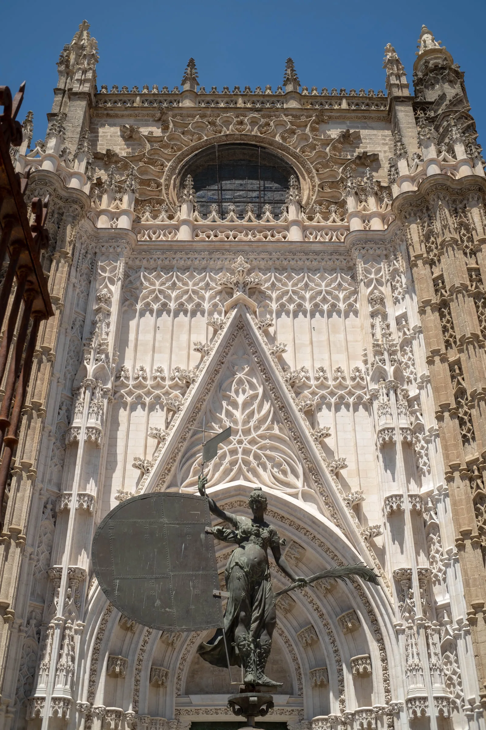 The ornate Gothic west front of Seville Cathedral with the Giraldillo statue in front of it