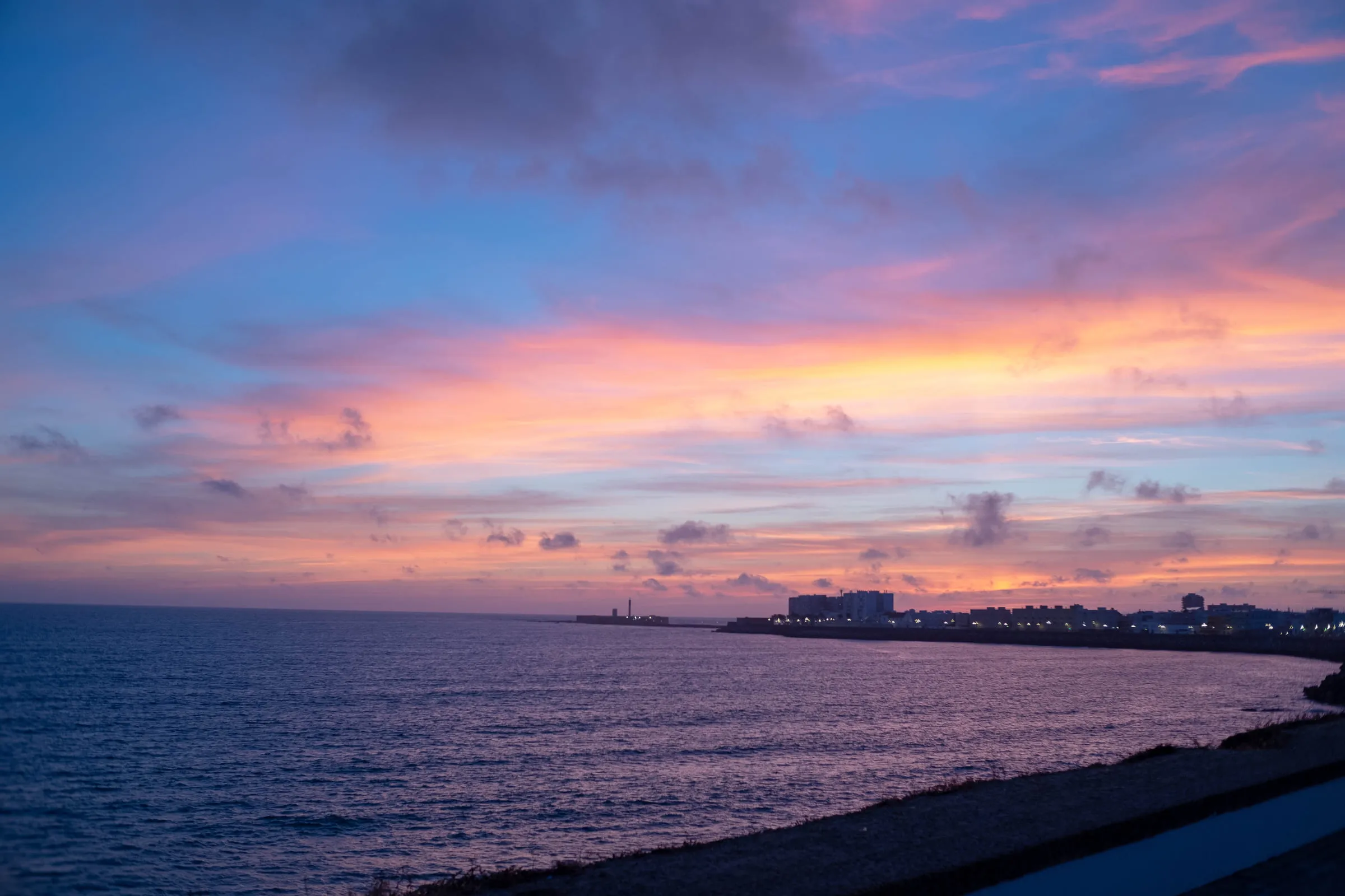 Pink and violet sunset clouds over the Atlantic along the Cádiz seafront
