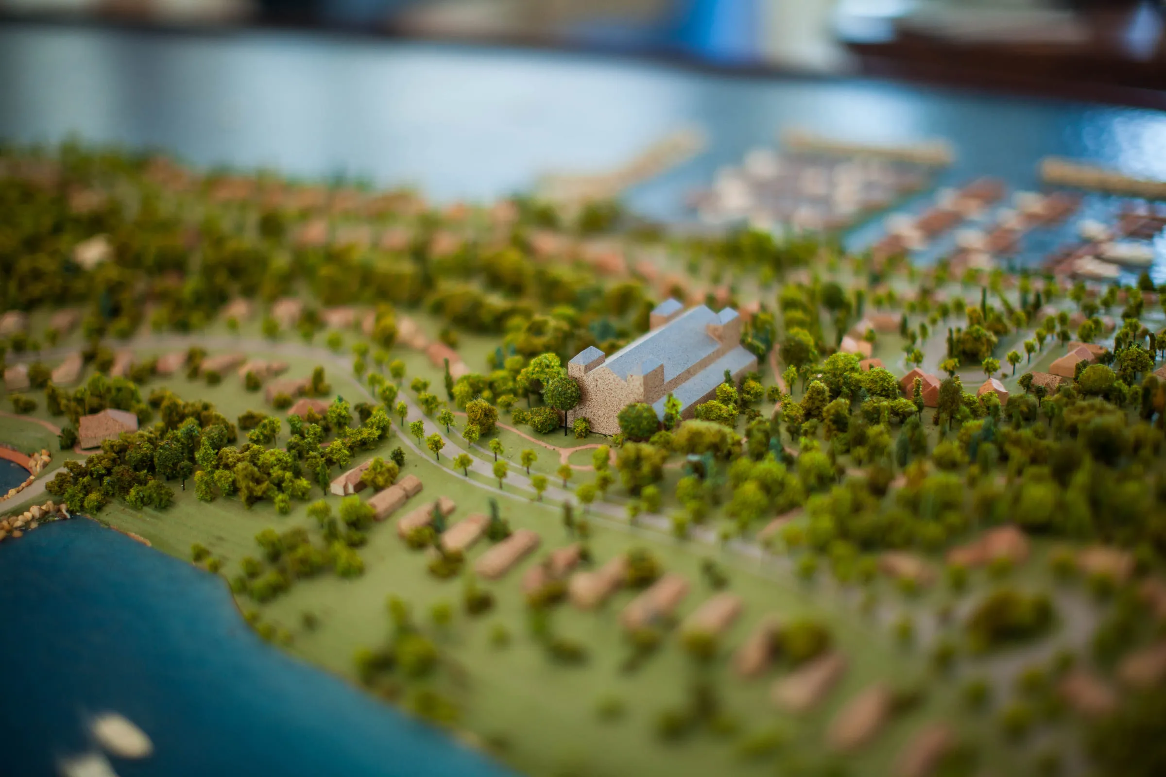 A scale model of the island seen close, tiny trees and buildings running down to blue water