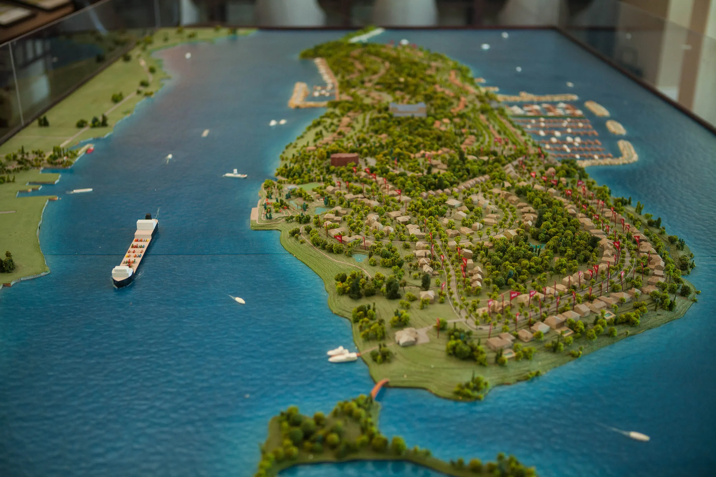 A large scale model of the island in a display case, a freighter on the river beside it
