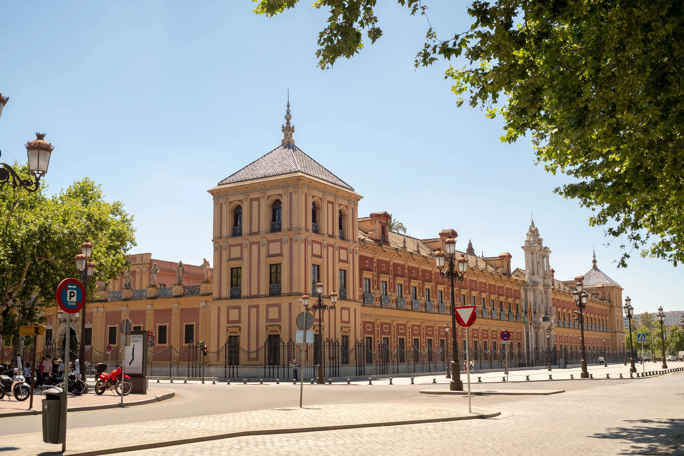 The long baroque facade of the San Telmo Palace in Seville under a clear sky