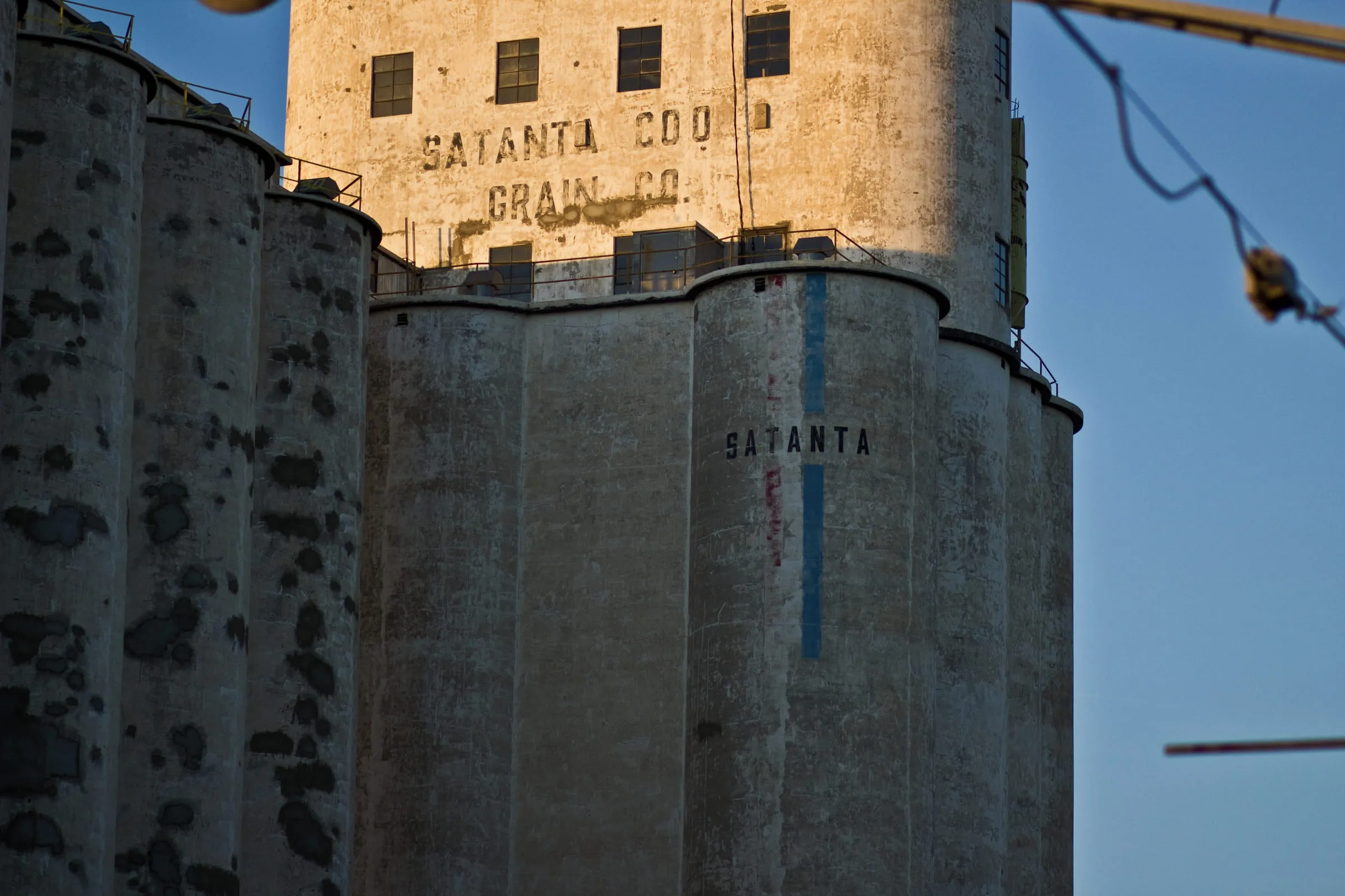 Concrete grain silos with SATANTA COOP GRAIN CO. painted across the headhouse